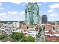 Stunning aerial view of the modern glass skyscraper with cityscape views and blue skies at 110 N Corcoran St # 2304, Durham, NC 27701