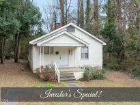 Charming single-story home with a white exterior, small porch, and well-established landscaping at 1219 Carlton Ave, Raleigh, NC 27606