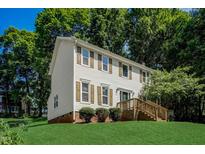 Charming two-story home featuring light siding, green lawn, and mature trees at 207 Wyatts Pond Ln, Cary, NC 27513