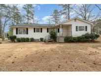 Charming single-story home with a welcoming front porch and mature trees at 241 S Plank Rd, Sanford, NC 27330