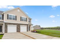 Charming two-story townhome featuring a stone facade, two-car garage, and well-manicured lawn at 268 Moyer Dr, Graham, NC 27253