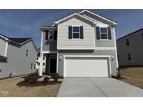 Charming two-story home featuring a two-car garage, beautiful landscaping, and modern architectural details at 2701 Princess Tree Dr, Raleigh, NC 27616