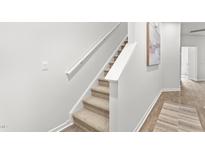 Carpeted staircase with white railings ascends to the next level in this neutrally decorated home at 280 Moyer Dr, Graham, NC 27253