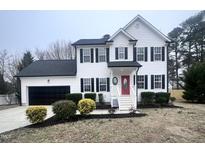 Beautiful two-story home with black shutters, a red door and a well manicured lawn at 3 Azzi Ct, Durham, NC 27703