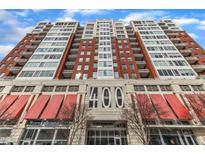 View of the front of the building with '400' numbering in the entryway and red awnings at 400 W North St # 1114, Raleigh, NC 27603
