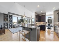 Modern kitchen featuring granite countertops, dark cabinetry, stainless steel appliances, and a breakfast bar with seating at 400 W North St # 730, Raleigh, NC 27603