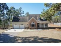 Charming two-story home with brick and vinyl siding, a two car garage, and a well manicured lawn at 74 Wildcat Ln, Cameron, NC 28326