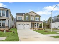 Beautiful two-story home featuring a two-car garage, covered porch, and manicured lawn at 749 Aristocrat Ln, Knightdale, NC 27545