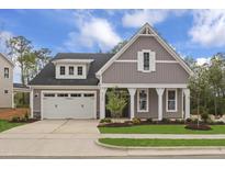 Charming craftsman-style home with gray siding, white trim, a manicured lawn, and a two-car garage at 9169 Dupree Meadow Dr # 26, Angier, NC 27501