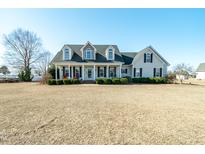 Charming two-story home featuring dormer windows and a welcoming front porch at 105 Bagley Ln, Dunn, NC 28334