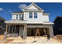 Two-story home with light gray siding, stone accents, and an attached two-car garage at 107 Willow Cameron Way, Angier, NC 27501