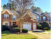 Charming brick townhome featuring a one-car garage and well-manicured landscaping at 11213 Presidio Dr, Raleigh, NC 27617