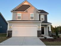 Beautiful two-story home with stone accents, gray siding, and a spacious two-car garage at 135 Willow Cameron Way, Angier, NC 27501