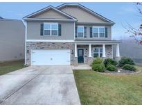 Charming two-story home featuring stone accents, a two-car garage, and a well-maintained front yard at 151 N Great White Way, Clayton, NC 27527