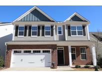 Charming two-story home with brick and siding, attached garage, and well-manicured lawn at 2100 Curry Meadow Way, Durham, NC 27703