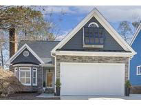 Charming home featuring a stone facade, two-car garage, and gabled roof detail at 2949 Tillinghast Trl, Raleigh, NC 27613