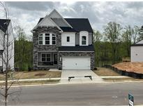 Charming two-story home with stone accents and a well-manicured front yard and attached two car garage at 4404 Emeline Way # 35, Fuquay Varina, NC 27526