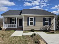 Charming single-story home with a cozy front porch and neatly landscaped yard at 5520 Neuse View Dr, Raleigh, NC 27610