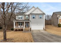 Charming two-story home featuring a covered front porch, a two-car garage, and neutral siding at 617 Hope Valley Rd, Knightdale, NC 27545