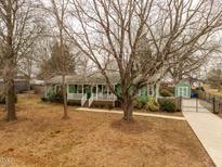 Charming green home with a lovely front porch and mature trees in a tranquil setting at 623 Rolling Rd, Haw River, NC 27258