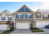 Charming townhome features a garage, blue shutters, and manicured landscaping at 6339 Grace Lily Dr, Raleigh, NC 27607