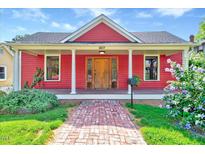 Charming red home featuring a brick walkway, covered porch, white columns and beautiful landscaping at 807 Vickers Ave, Durham, NC 27701