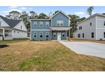Charming two-story home featuring a spacious front yard and a modern blue facade at O Shortline Rd, Roxboro, NC 27574
