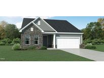 Charming home featuring stone and vinyl siding, complemented by a well-manicured lawn and attached garage at 1702 Red Roses Ave, Durham, NC 27703