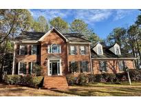 Beautiful brick home featuring manicured landscaping and traditional architectural details at 1809 Waddill Way, Henderson, NC 27536