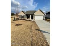 Charming single-story home featuring a two-car garage and a well-manicured lawn at 19 Oriental St, Angier, NC 27501