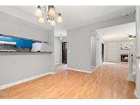 Bright dining room with wood floors, modern lighting, and a view to the kitchen and living areas at 230 Finley Forest Dr, Chapel Hill, NC 27517