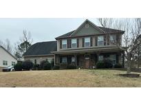 Charming two-story home featuring a covered porch, stone accents, and well-manicured landscaping at 248 Swann Trl, Clayton, NC 27527
