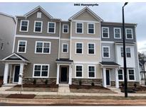 New townhome exteriors featuring varied siding colors, stone accents and manicured front yard landscaping at 3002 Honeymyrtle Ln, Durham, NC 27703