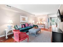 Inviting living room featuring a plush green sofa, stylish decor, and a bright, airy atmosphere at 3716 Yorktown Pl, Raleigh, NC 27609