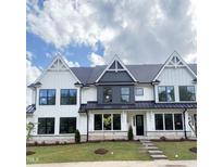 Charming white and gray townhouse featuring manicured lawn and modern architectural details at 905 Myers Point Dr, Morrisville, NC 27560