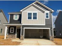 New construction home featuring a two-car garage and a combination of siding and stone accents at 97 Willow Cameron Way, Angier, NC 27501