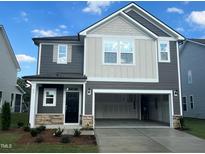 Charming two-story home featuring a two-car garage, stone accents, and a combination of siding and shingles at 97 Willow Cameron Way, Angier, NC 27501