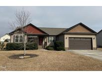 Charming home featuring a two-car garage, well-maintained lawn, and inviting curb appeal at 102 Westchase Dr, Clayton, NC 27527