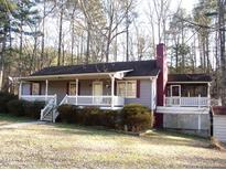 Charming single-story home with a spacious front porch and well-maintained landscaping at 105 Lake Rd, Henderson, NC 27537