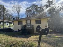 Quaint bungalow featuring dual mailboxes and a cozy front porch, set amongst a backdrop of bare trees and blue skies at 107 Creel St, Chapel Hill, NC 27516