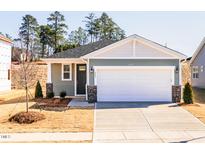 Charming single-story home boasts a two-car garage and a manicured front lawn at 203 Little Crk Dr, Lillington, NC 27546