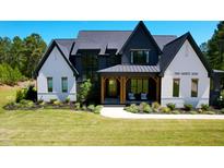 Beautiful two-tone home featuring contrasting white and black accents, stylish front porch, and manicured lawn at 299 Seaforth Landing Dr, Pittsboro, NC 27312