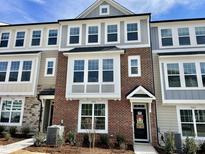 Charming townhome showcasing a brick facade with large windows and a welcoming entrance at 3024 Freewinds Way # 49, Cary, NC 27519