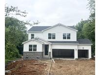 New two-story home with white siding, stone accents, and a two-car garage, situated on a large lot at 362 Barbour Farm Ln, Four Oaks, NC 27524