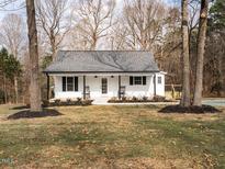 Charming single-story home featuring a cozy front porch with rocking chairs and well-maintained landscaping at 4664 Quarter Creek Ln, Liberty, NC 27298