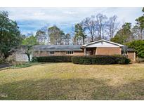 Charming single-story brick home with a well-maintained lawn and mature trees at 4701 Morehead Dr, Raleigh, NC 27612