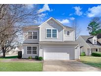 Charming two-story home features a two-car garage, well-maintained lawn, and light gray siding at 5416 Kissimmee Ln, Raleigh, NC 27616