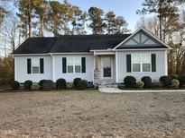 Charming single-story home with light gray siding, black shutters, and landscaped front yard at 5663 Godwin Lake Rd, Benson, NC 27504