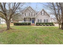 Charming two-story home with a welcoming front porch and well-manicured lawn at 6002 Rustic Wood Ln, Durham, NC 27713