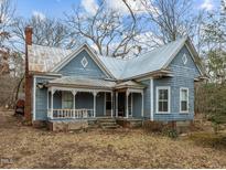 Charming blue home featuring detailed wood shingles, metal roof and a front porch at 753 Smith Level Rd, Chapel Hill, NC 27516